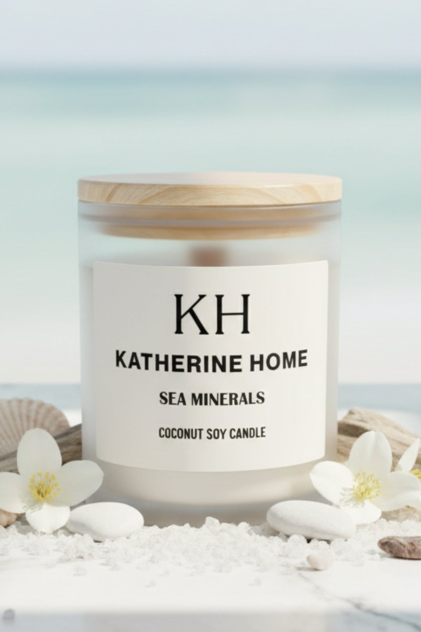 Candle labeled 'KH Katherine Home' with sea minerals on a beach setting