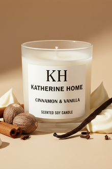 Scented candle labeled 'KH Katherine Home' with cinnamon, vanilla, and nuts on a beige background