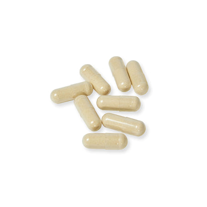 Close-up flat lay of beige Ashwagandha and Black Pepper vegetable capsules against a white background.