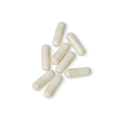 Close-up flat lay of Katherine Home 5-HTP capsules on a white surface, highlighting their smooth capsule form.