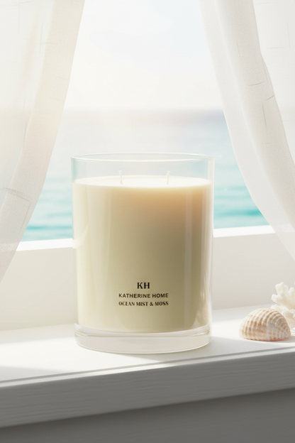 Ocean Mist & Moss Scented Candle on windowsill with ocean view, evoking coastal freshness and tranquility.