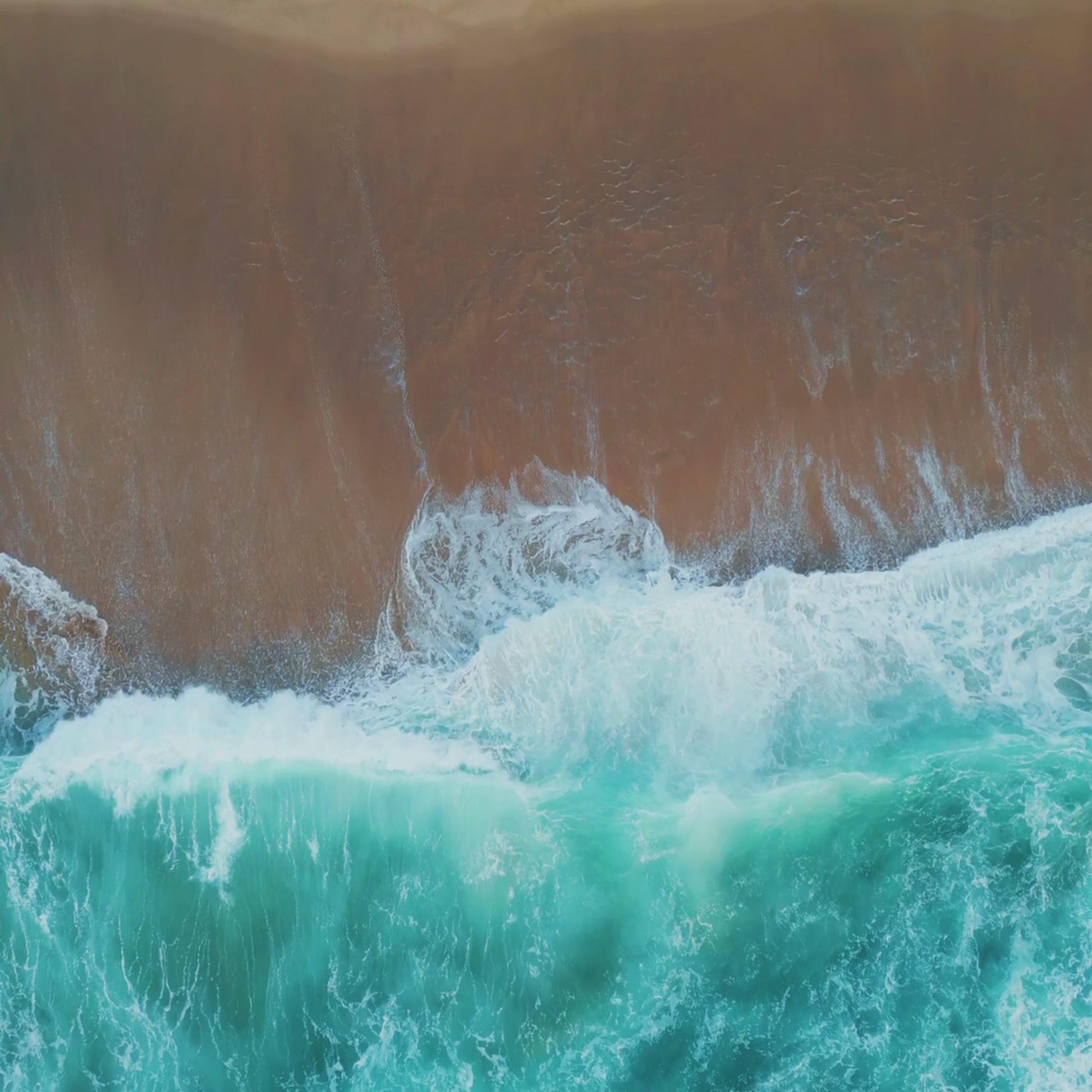 Video of ocean waves rolling onto the shore, representing the fresh, coastal scent of the Katherine Home Ocean Mist & Moss candle.