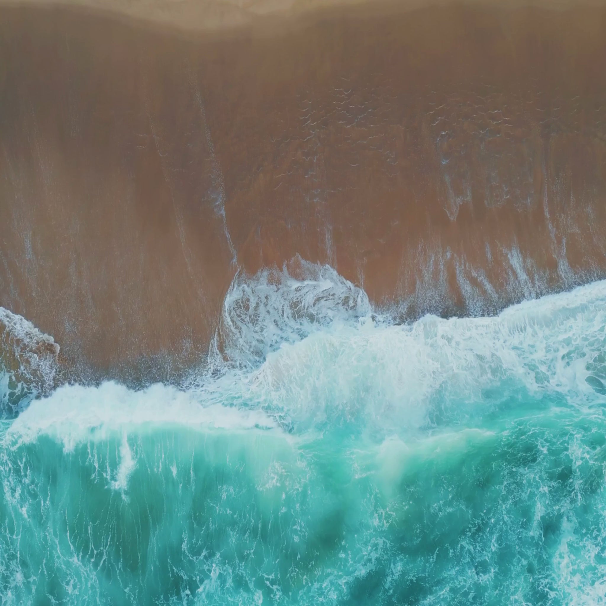 Video of ocean waves rolling onto the shore, representing the fresh, coastal scent of the Katherine Home Ocean Mist & Moss candle.